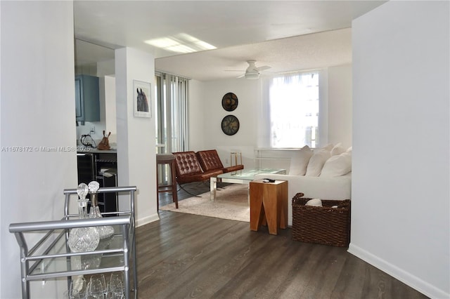 living room with dark hardwood / wood-style flooring and ceiling fan