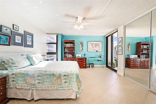 5550 N Ocean Dr Unit 8B, Singer Island, FL 33404 - bedroom featuring a textured ceiling, a ceiling fan, tile patterned floors, and multiple closets