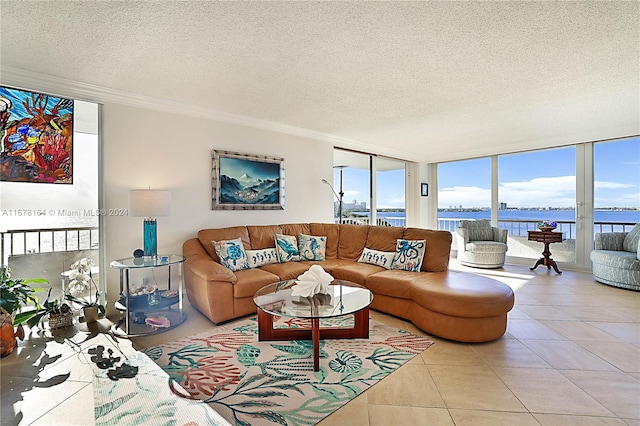 living room featuring a water view, a textured ceiling, floor to ceiling windows, and light tile patterned flooring