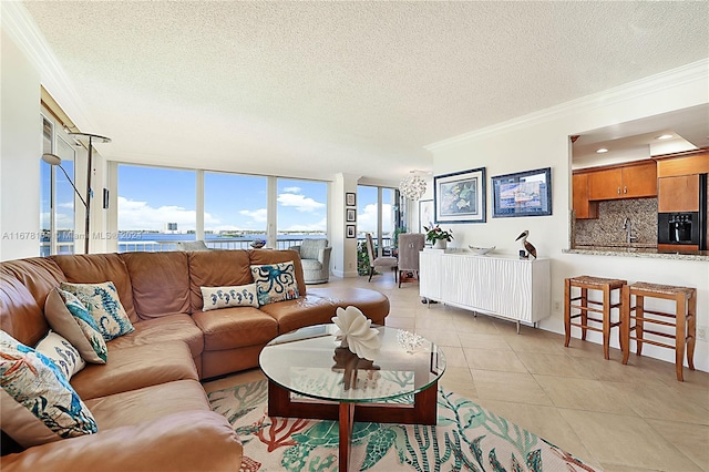 5550 N Ocean Dr Unit 8B, Singer Island, FL 33404 - living area with crown molding, a textured ceiling, a chandelier, and light tile patterned flooring