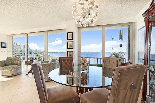 dining area featuring a water view, a textured ceiling, crown molding, and light tile patterned floors