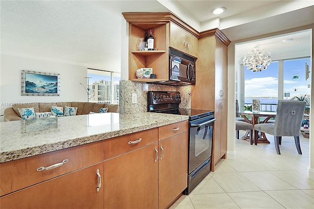 kitchen with decorative backsplash, plenty of natural light, black appliances, and light stone counters