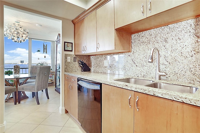 5550 N Ocean Dr Unit 8B, Singer Island, FL 33404 - kitchen with black dishwasher, decorative backsplash, light tile patterned flooring, light stone countertops, and a chandelier