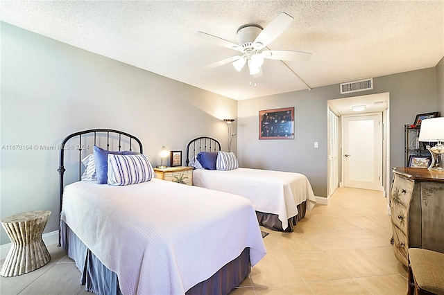 bedroom with light tile patterned flooring, ceiling fan, and a textured ceiling