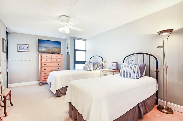 tiled bedroom featuring a textured ceiling and ceiling fan