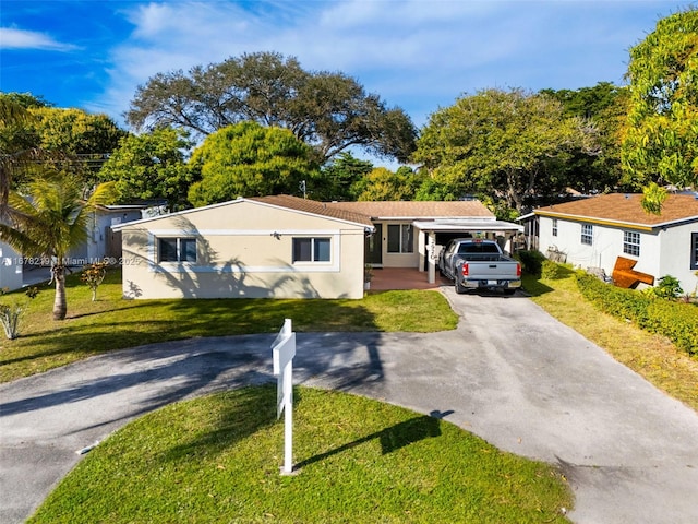 view of front of property with a carport and a front lawn