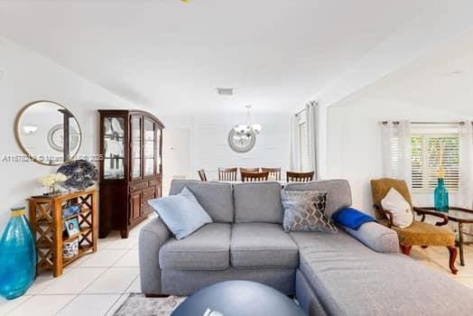 tiled living room featuring an inviting chandelier