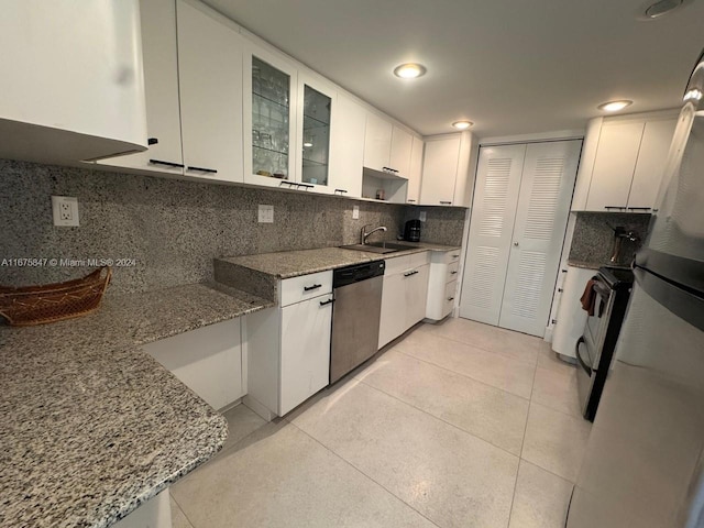 kitchen with white cabinets, stainless steel appliances, and light stone counters