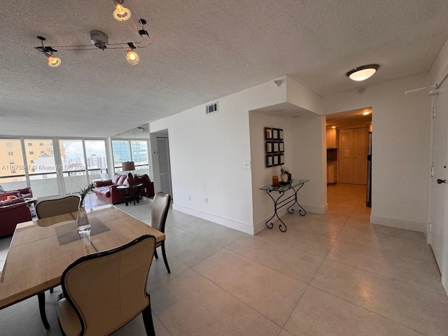 dining space featuring a wall of windows and a textured ceiling