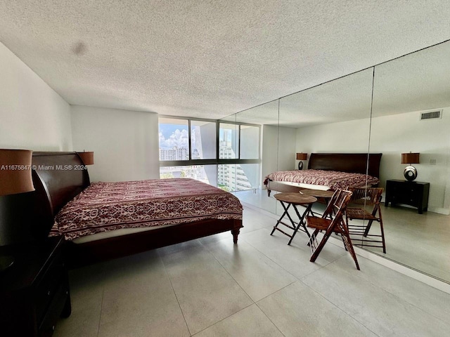 bedroom featuring expansive windows and a textured ceiling