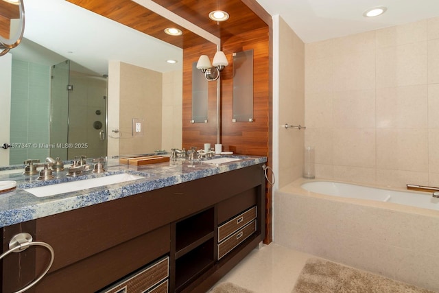 bathroom featuring shower with separate bathtub, tile patterned flooring, tile walls, and vanity