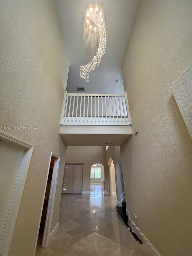 stairs featuring a towering ceiling and an inviting chandelier