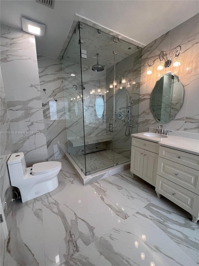 bathroom featuring tile walls, vanity, a shower with shower door, and toilet