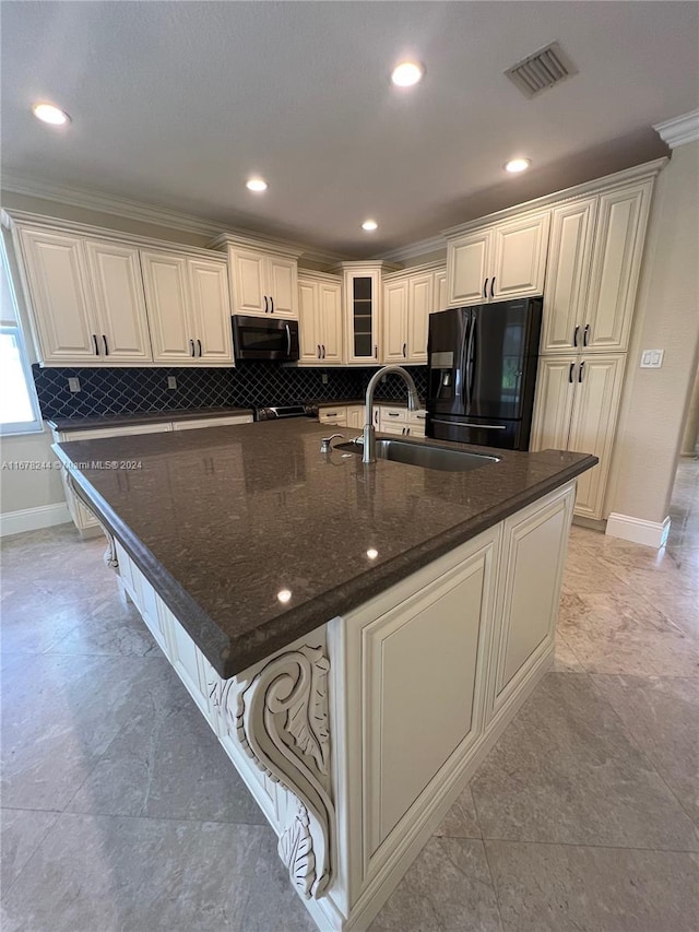 kitchen featuring a large island with sink, dark stone counters, black fridge with ice dispenser, ornamental molding, and sink