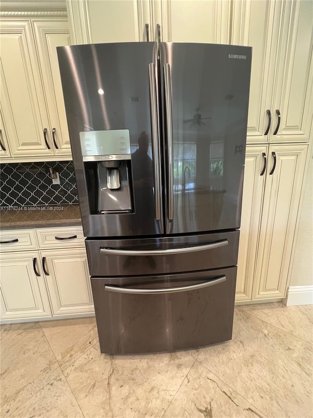 details with stainless steel fridge, tasteful backsplash, and cream cabinetry