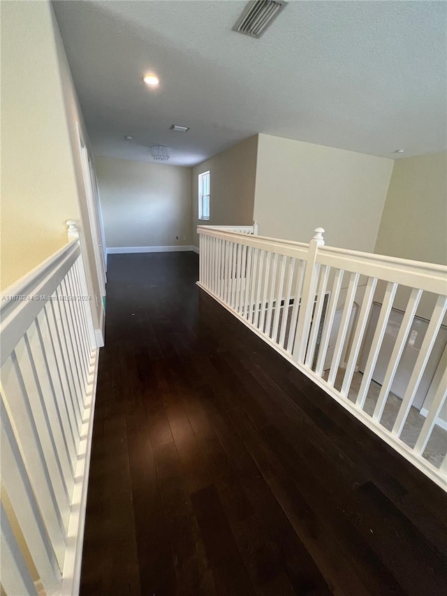 corridor with dark hardwood / wood-style flooring