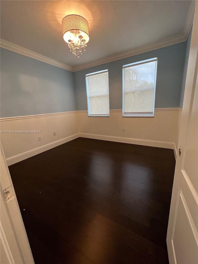 unfurnished room with crown molding, a chandelier, wood-type flooring, and a wealth of natural light