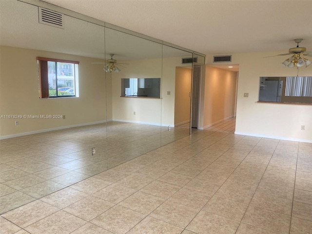 unfurnished living room with light tile patterned flooring and ceiling fan