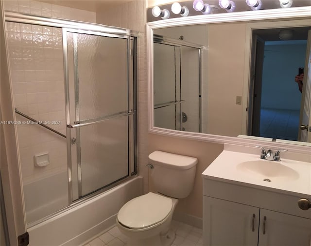 full bathroom featuring vanity, toilet, tile patterned floors, and bath / shower combo with glass door