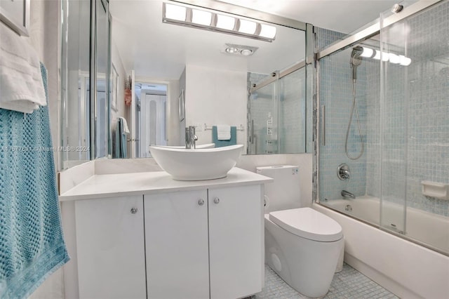 full bathroom featuring vanity, combined bath / shower with glass door, toilet, and tile patterned floors