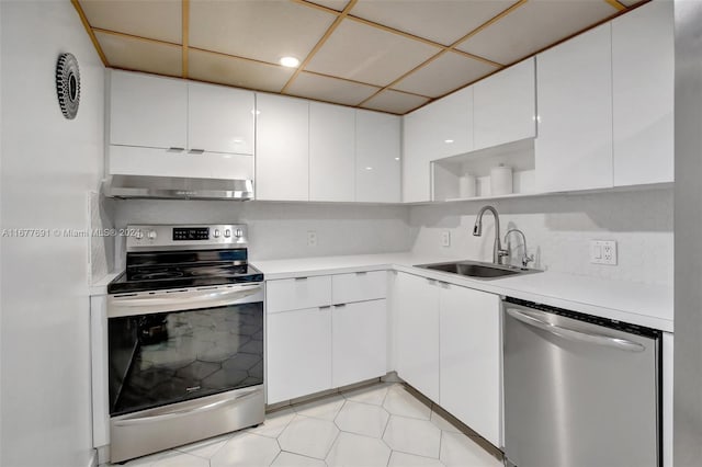 kitchen featuring tasteful backsplash, sink, white cabinetry, stainless steel appliances, and range hood