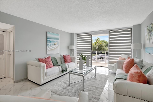 tiled living room featuring a textured ceiling