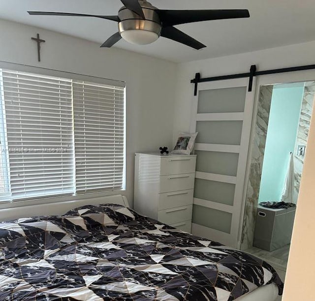 bedroom with a barn door and ceiling fan