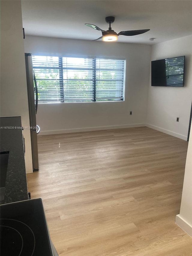 unfurnished room with light hardwood / wood-style floors, a healthy amount of sunlight, and ceiling fan