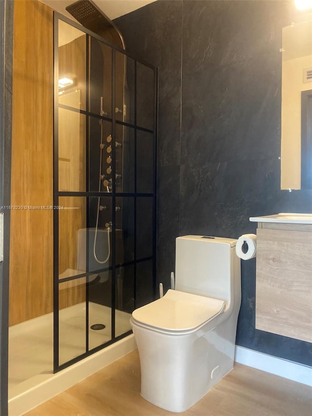 bathroom featuring vanity, toilet, wood-type flooring, and walk in shower