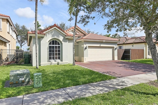 mediterranean / spanish-style home featuring a garage and a front lawn