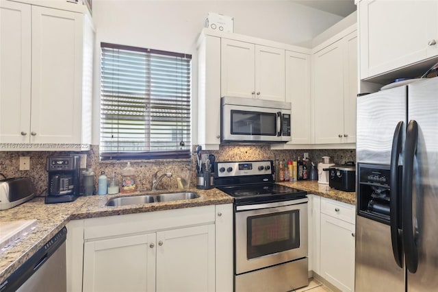 kitchen featuring decorative backsplash, white cabinetry, appliances with stainless steel finishes, and a sink