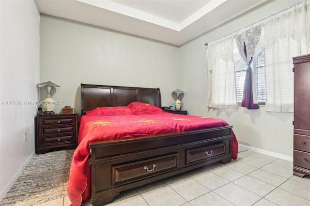 bedroom with light tile patterned floors and baseboards