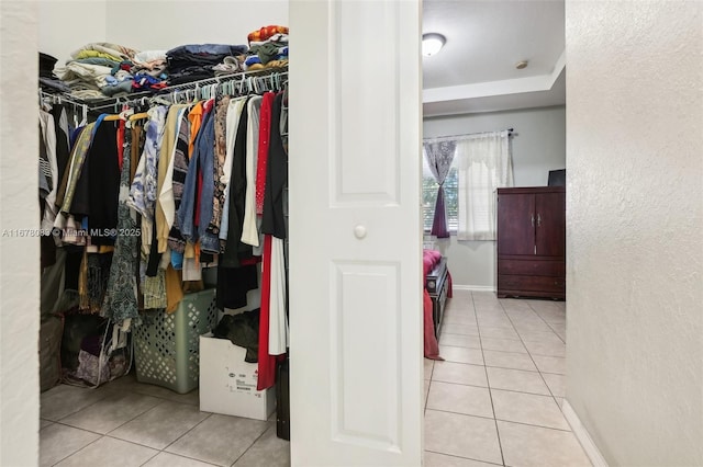 walk in closet with light tile patterned floors