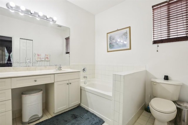 bathroom featuring vanity, a garden tub, toilet, and tile patterned floors