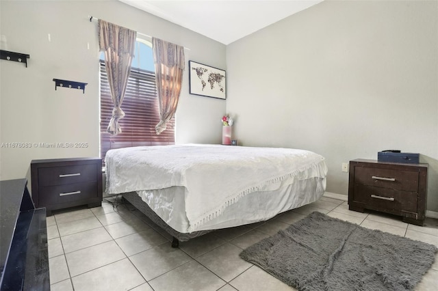 bedroom featuring light tile patterned flooring and baseboards