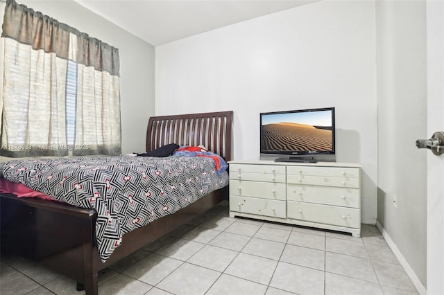 bedroom with light tile patterned floors and baseboards