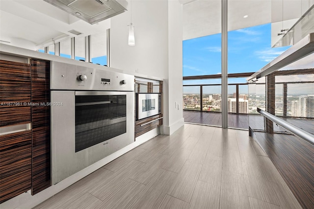 kitchen featuring hardwood / wood-style floors, stainless steel oven, floor to ceiling windows, and pendant lighting