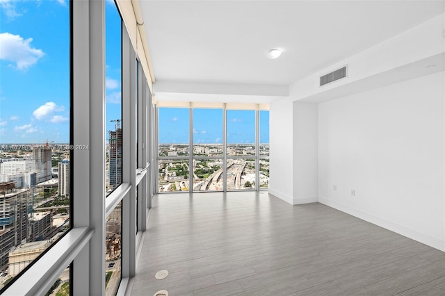 spare room with wood-type flooring and expansive windows