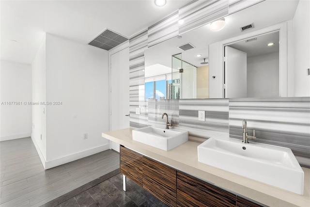 bathroom with vanity, a shower, decorative backsplash, and wood-type flooring