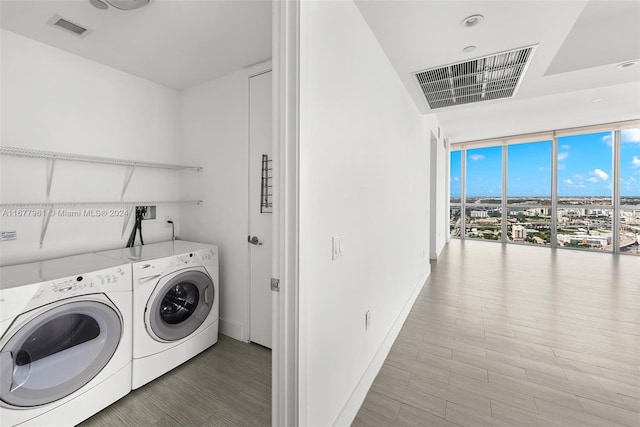 laundry room with washing machine and dryer and wood-type flooring