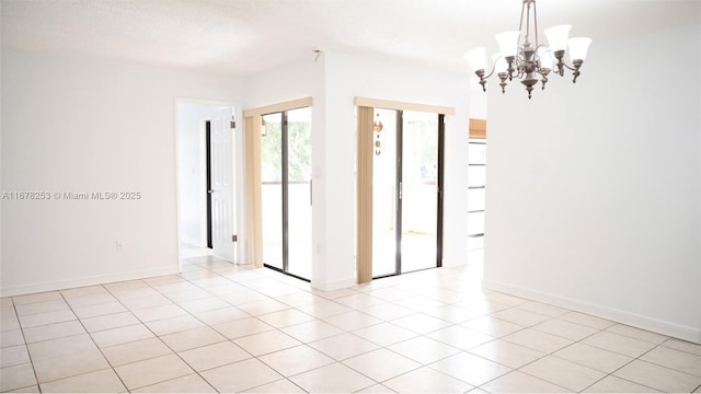 spare room featuring an inviting chandelier, light tile patterned floors, and a textured ceiling