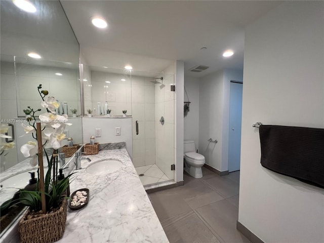 bathroom featuring vanity, toilet, baseboards, a shower stall, and visible vents