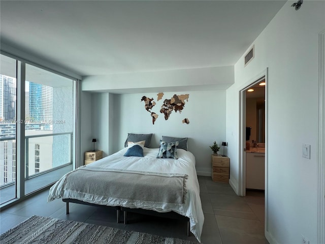 tiled bedroom featuring access to exterior, multiple windows, and ensuite bath