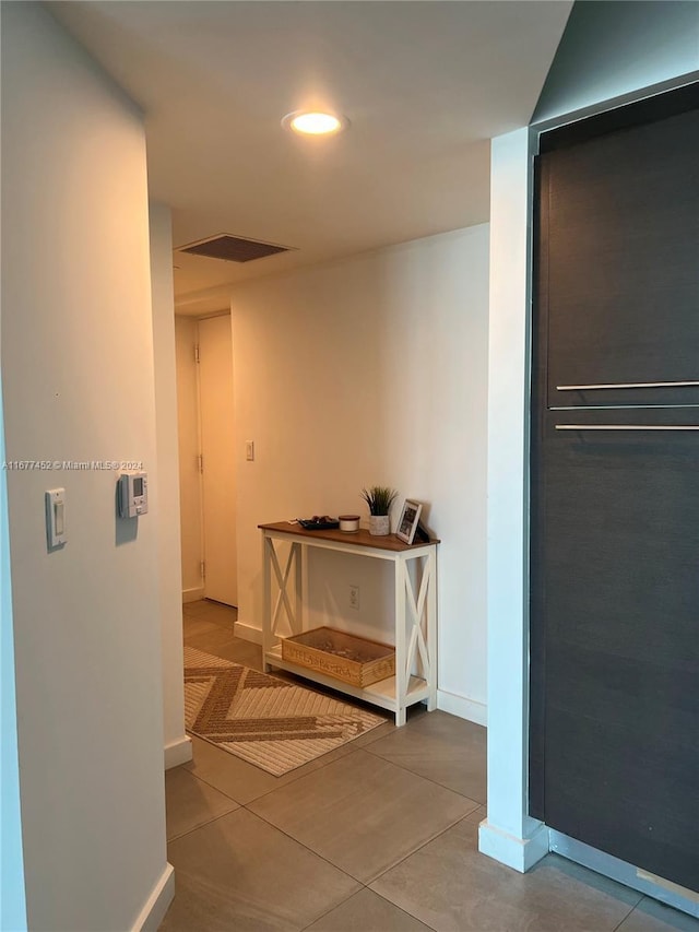 hallway featuring baseboards, recessed lighting, tile patterned floors, and visible vents