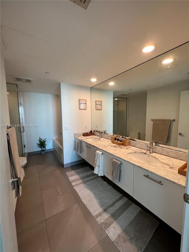 full bathroom featuring double vanity, a shower stall, a sink, toilet, and recessed lighting