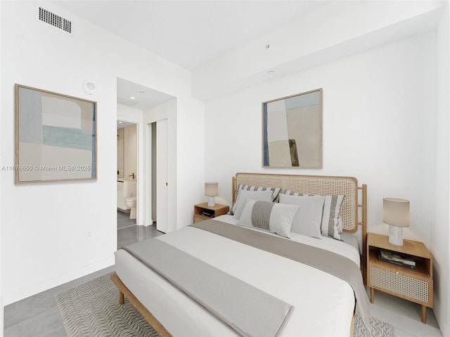 bedroom with visible vents, baseboards, and ensuite bathroom