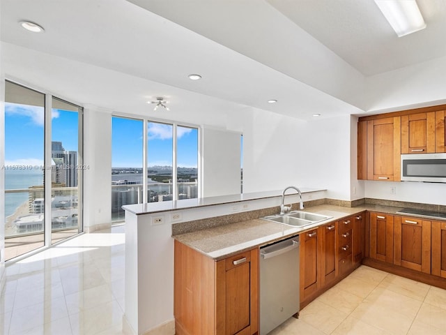 kitchen featuring kitchen peninsula, sink, light tile patterned flooring, appliances with stainless steel finishes, and a water view