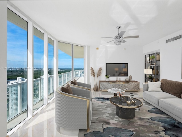 living room with floor to ceiling windows, plenty of natural light, and ceiling fan