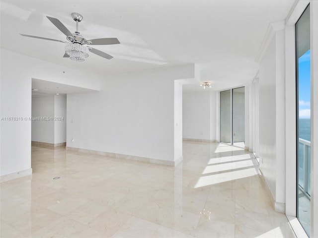 empty room featuring crown molding and ceiling fan