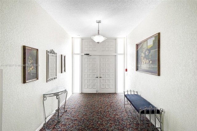 hall featuring french doors and a textured ceiling